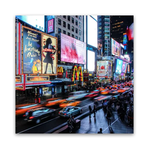 Night view of Times Square featuring illuminated billboards and moving traffic.
