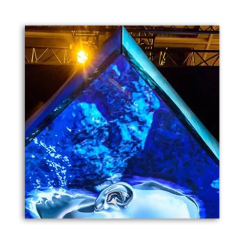 A pyramid-shaped structure with a blue illuminated surface reflecting light.