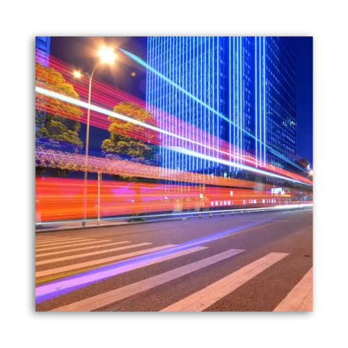 Long exposure photograph of a city street at night showing light trails from vehicles.