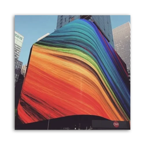 Large abstract mural featuring vibrant colors on the side of a building in an urban setting.