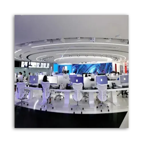 A modern office workspace featuring multiple computers arranged in a circular layout with ergonomic chairs.