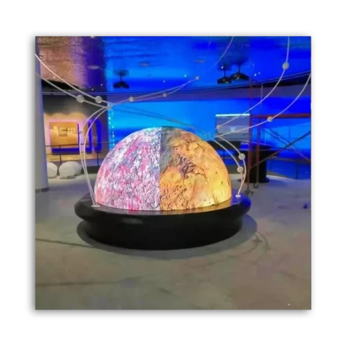 A large illuminated globe display with a split design showing different textures and colors.